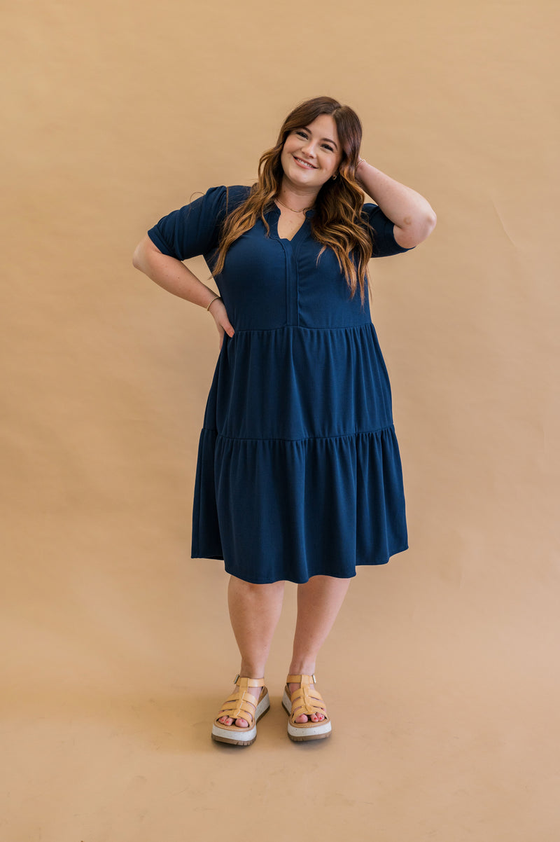 Navy Tiered dress on size XL  model. Model looks adorable in the knee length cut of this navy dress. 