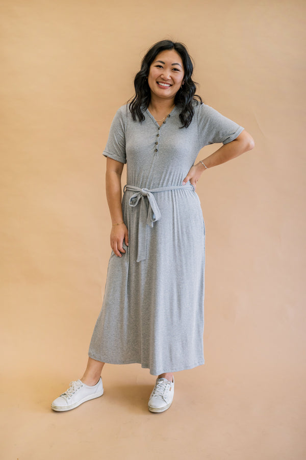 Model showcasing Merrick White's modest, machine washable gray ribbed henley dress with rolled sleeves