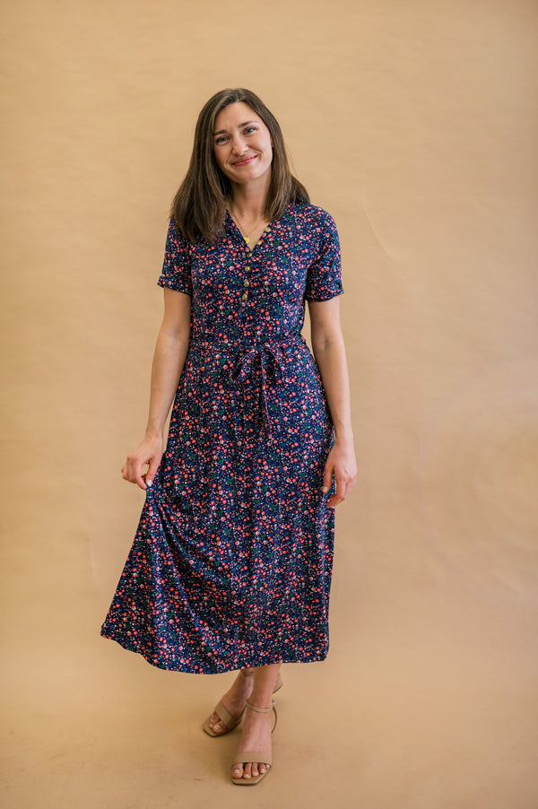Model in Floral Patterned Navy dress with gold functional buttons